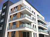 Balkonhek van glazen balustrade en franse balkons met glazen raambalustrade. Rvs staanders en leuningen. Vulling van veiligheidsglas
