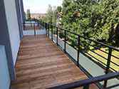 Balkon met stalen constructies, houten vloerdelen en balustrades met glazen vulling