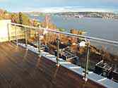 Dakterrashek van glazen balustrade met rond hoog gepolijst rvs staanders en leuningen. Balustradevulling van veiligheidsglas