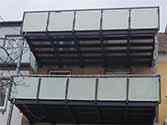 Balkon met draagstructuur van stalen profielen en glazen balustrade
