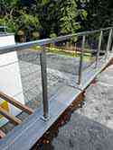 Balustrade met rvs staanders en leuningen van vierkante buis. Vulling van gelaagd, veiligheidsglas VSG