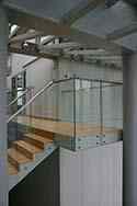 Volledig glazen balustrade met rond hoog gepolijst rvs leuning.