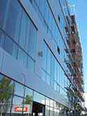Gevel bedekt met glaspanelen en Alucobond (aluminium composiet materiaal) gevelpanelen gemonteerd op een aluminium structuur