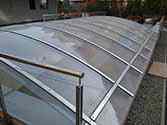 Dak over oprit naar de ondergrondse parkeergarage. Polycarbonaatplaten gemonteerd op draagconstructie met stalen platen