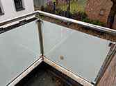 Balkonhek van glazen balustrade met rvs staanders en leuningen