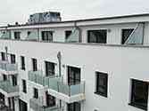 Scheidingswand met glazen panelen in rvs frames op balkon