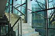 Glazen balustrade met rond rvs staanders en leuningen. Balustradevulling van veiligheidsglas