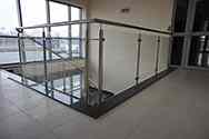 Glazen balustrade met rvs staanders en leuningen aan de bovenkant van de trap