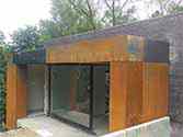 Gevelbekleding met Corten staalplaten van ingang van het huis
