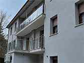 Balkonhek van glazen balustrade met rvs staanders en leuningen