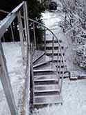Spiltrap met rvs steunstructuur en traptreden van aluminiumplaat. Balustrade met rvs staanders en leuningen