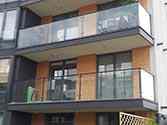 Balkonhek van balustrade met stalen staanders en leuningen. Balustradevulling van veiligheidsglas gemonteerd met rvs glasadapters