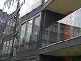Franse balkons van glasplaat gemonteerd op stalen frames met rvs glasadapters