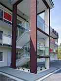 Hoog gepolijst rvs staanders en leuningen. Balustradevulling van gehard glaspanelen. Gemonteerd op buiten trappen