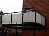 Balkon met glazen balustrade met stalen staanders en leuningen.