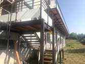 Trap en balkon van staal en hout met balustrades met glazen vulling