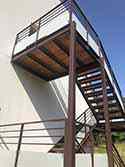 Trap van staal en hout met balustrades met glazen vulling.