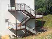 Trap van staal en hout met balustrades met glazen vulling.