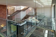 Hangend tussenverdieping met stalen constructie, glazen paneelvloer en volledig glazen balustrade