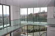 Hangende tussenverdieping met stalen constructie, glazen paneelvloer en volledig glazen balustrade met rvs handregel